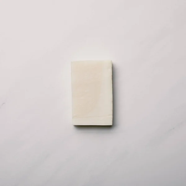 Vista superior da peça de sabão na superfície de mármore branco — Fotografia de Stock