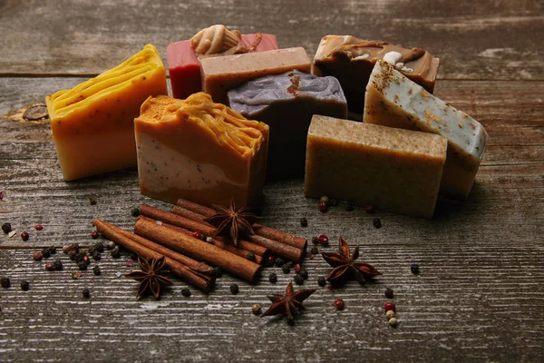 Close-up shot of homemade soap pieces with spices on rustic wooden tabletop — Stock Photo