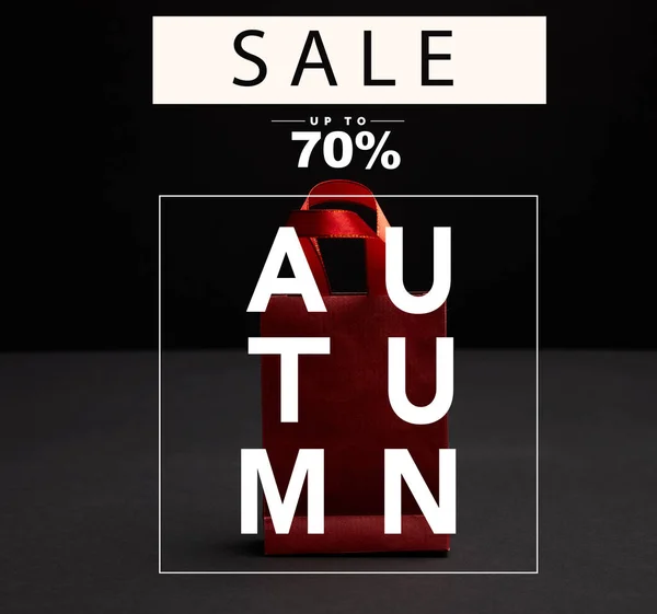 Vista de perto do saco de compras de papel vermelho no fundo preto com venda de outono, 70 por cento de desconto — Fotografia de Stock