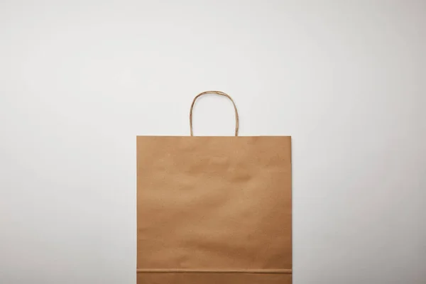 Acostado plano con bolsa de papel de entrega de alimentos en la superficie blanca, concepto minimalista - foto de stock