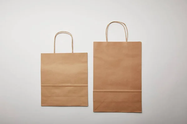 Vista elevata dei sacchetti di carta per la consegna dei prodotti alimentari su superficie bianca, concetto minimalista — Foto stock