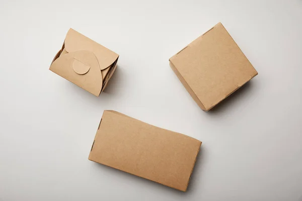 Top view of wok box and food delivery boxes on white surface — Stock Photo