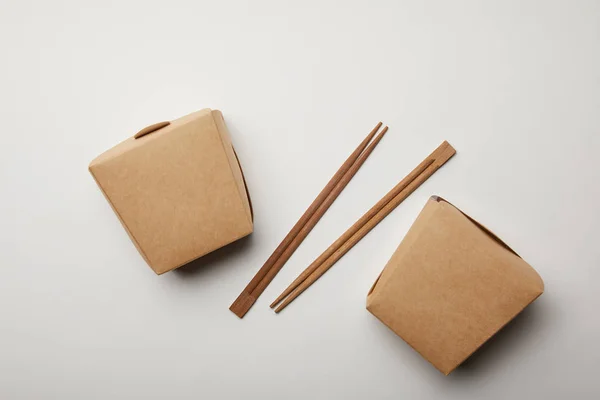 Flay lay with arranged chopsticks and noodle boxes on white surface, minimalistic concept — Stock Photo