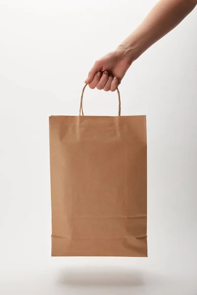 Imagem cortada de mulher segurando saco de papel com entrega de alimentos em branco — Fotografia de Stock