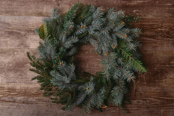 Vista superior de la corona de abeto de Navidad en la mesa de madera - foto de stock