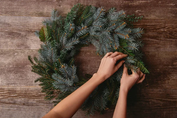 Imagem cortada de mulher fazendo grinalda de abeto de natal para decoração — Fotografia de Stock