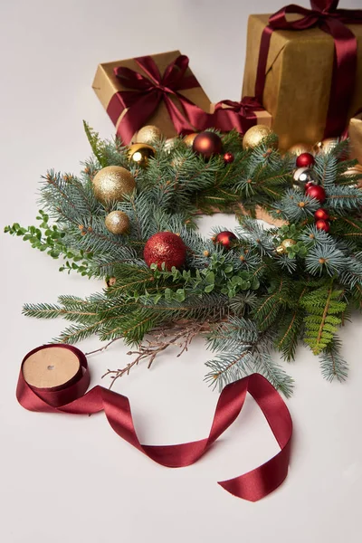 Scatole regalo di Natale, ghirlanda di abete e bobina di nastro per la decorazione isolata su bianco — Foto stock