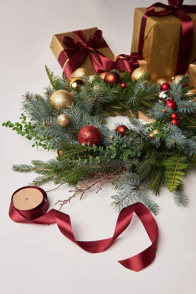 Christmas gift boxes, fir wreath and ribbon spool for decoration isolated on white — Stock Photo