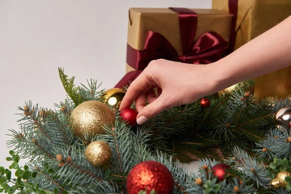 Image recadrée de femme décorant couronne de sapin de Noël avec des boules isolées sur blanc — Photo de stock