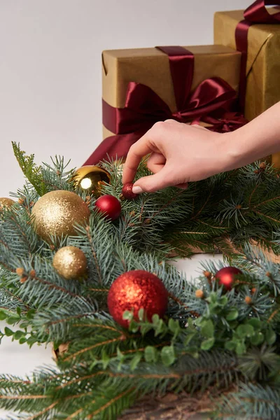 Cropped image of girl decorating christmas fir wreath isolated on white — Stock Photo