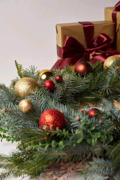 Corona de abeto de Navidad con adornos rojos y dorados, cajas de regalo aisladas en blanco — Stock Photo