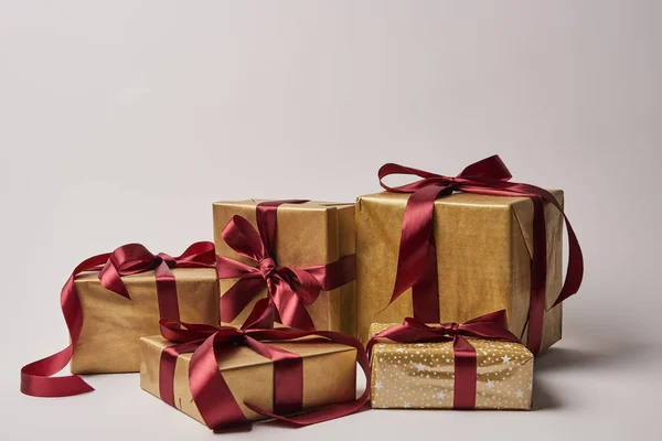 Christmas presents with burgundy ribbons isolated on white — Stock Photo