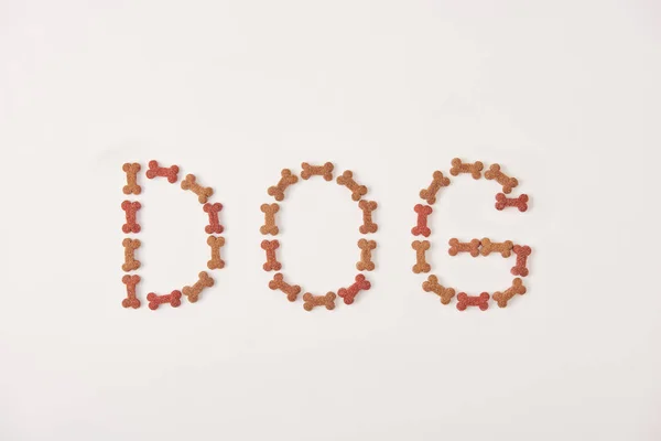 Vue de dessus du chien lettrage fait par la nourriture pour animaux de compagnie sur la surface blanche — Photo de stock