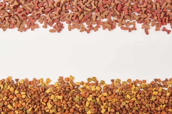 Top view of two pile of dog food on white surface — Stock Photo