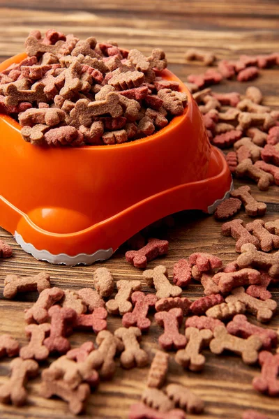 Nahaufnahme von Plastikschüssel mit Haufen Hundefutter auf Holztisch — Stockfoto