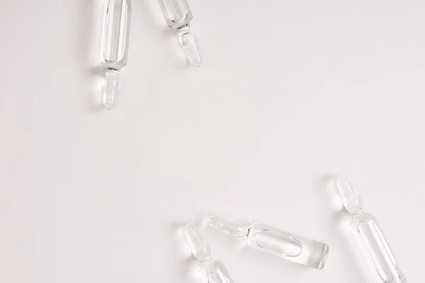 Vue surélevée des ampoules avec liquide médical sur surface blanche — Photo de stock