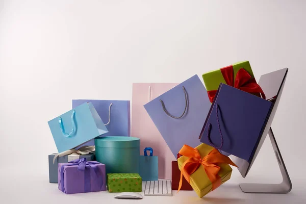 Side view of computer and colorful boxes with shopping bags on white, black friday concept — Stock Photo