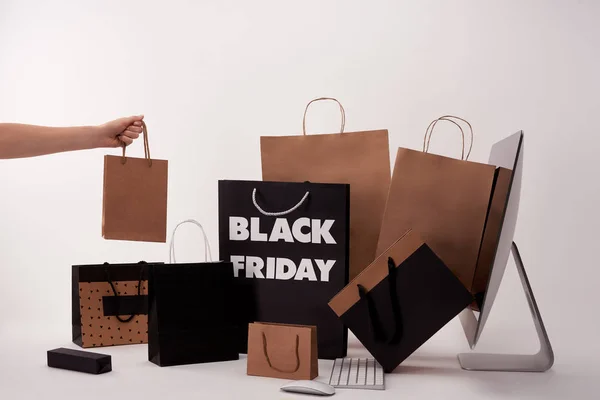Cropped shot of woman with different boxes with shopping bags near computer on white — Stock Photo