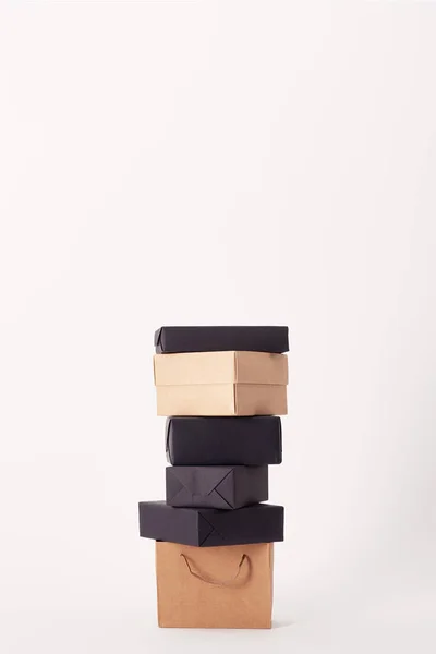 Saco de compras e caixas empilhadas na superfície branca, conceito preto sexta-feira — Fotografia de Stock