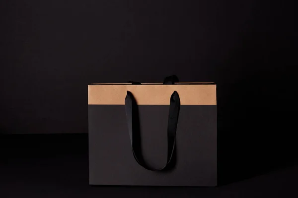 Primer plano de la bolsa de compras aislado en negro, concepto de viernes negro - foto de stock