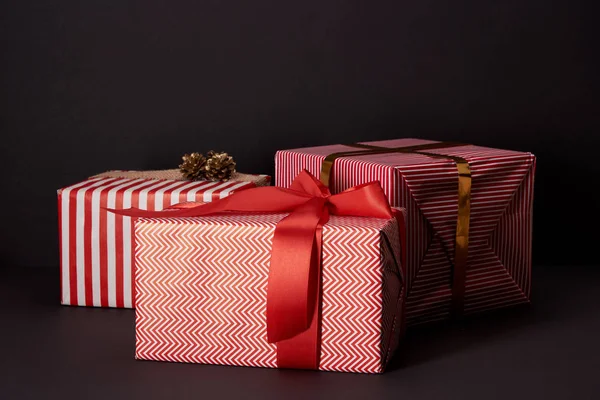 Wrapped gift boxes lying on black surface, black friday concept — Stock Photo