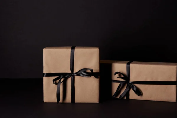 Wrapped gift boxes on black surface, black friday concept — Stock Photo