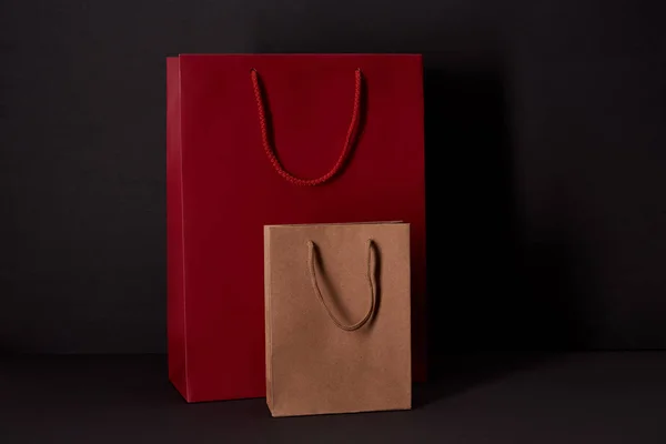 Bolsas de papel en la superficie negra, concepto de viernes negro - foto de stock