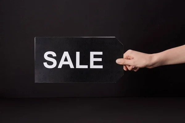 Plano recortado de la mujer sosteniendo la bandera con la inscripción de la venta aislado en negro, concepto de viernes negro - foto de stock