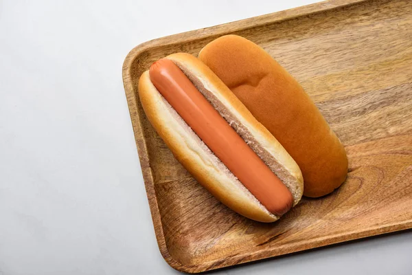 Draufsicht auf Hot Dog auf Holzbrett auf weißem Marmor — Stockfoto