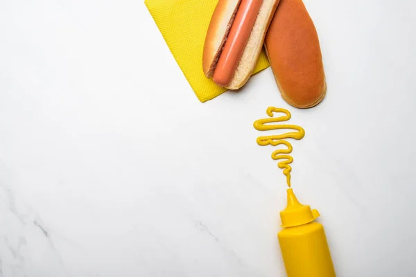 Top view of tasty hot dog with mustard on white marble surface — Stock Photo