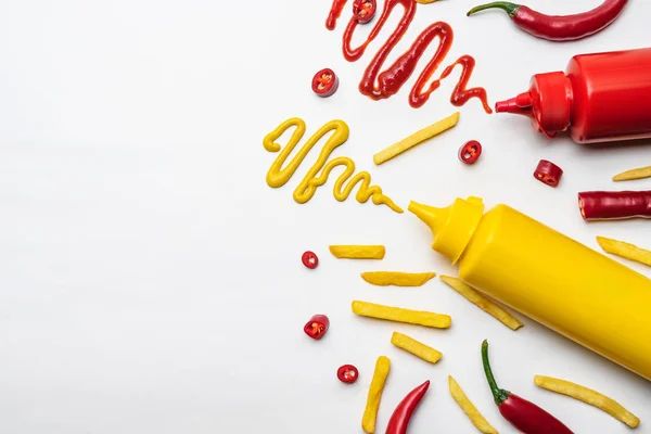 Vista dall'alto di patatine fritte con senape e ketchup su superficie bianca — Foto stock