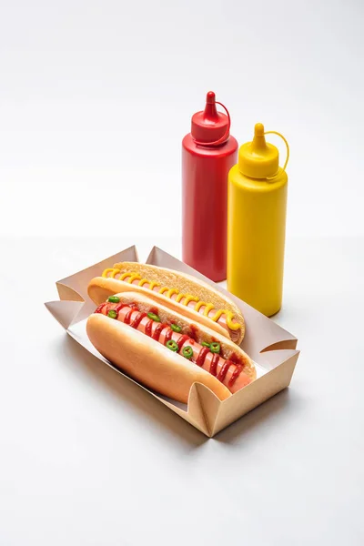 Close-up shot of spicy hot dogs with mustard and ketchup on white — Stock Photo