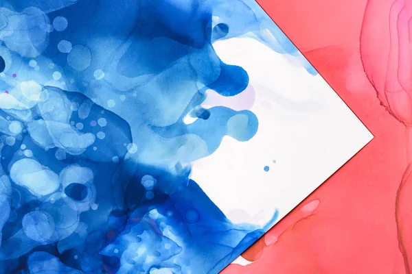 Red and blue splashes of alcohol inks on white as abstract background — Stock Photo