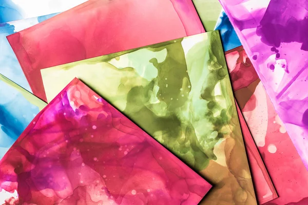 Éclaboussures vertes, rouges et violettes d'encres alcoolisées sur des feuilles de papier comme fond abstrait — Photo de stock