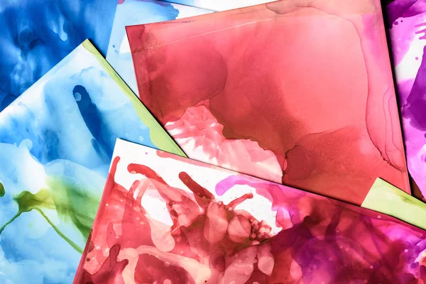 Blue, red and green splashes of alcohol inks on paper sheets as abstract background — Stock Photo