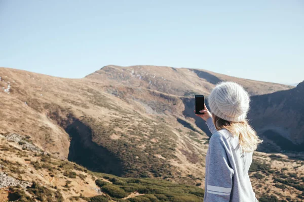 Vue arrière de la femme prenant des photos de montagne avec smartphone avec écran blanc, Carpates, Ukraine — Photo de stock