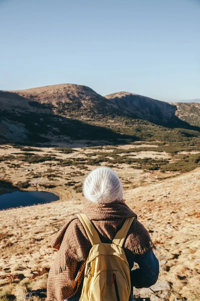 Rear view of female traveler looking at beautiful mountains and Nesamovyte lake, Carpathians, Ukraine — Stock Photo