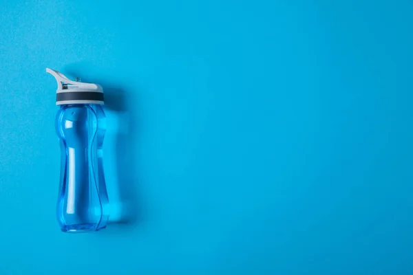 View from above of sport bottle with water isolated on blue, minimalistic concept — Stock Photo