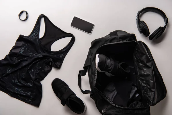 Vista sopraelevata di borsa sportiva con attrezzatura ginnica nera isolata su bianco — Foto stock