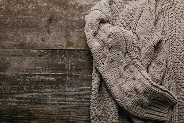 Vista dall'alto del maglione grigio lavorato a maglia su un tavolo di legno — Foto stock
