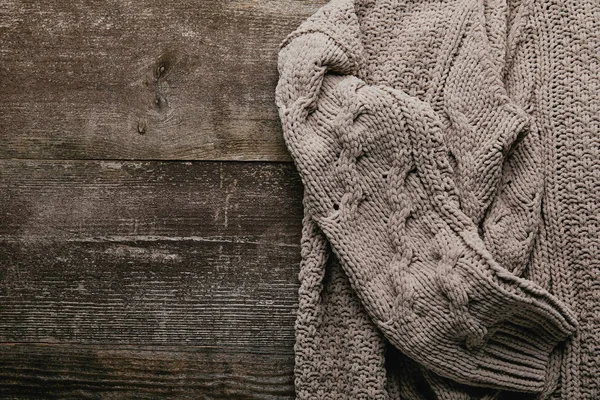 Top view of grey knitted sweater on wooden tabletop — Stock Photo