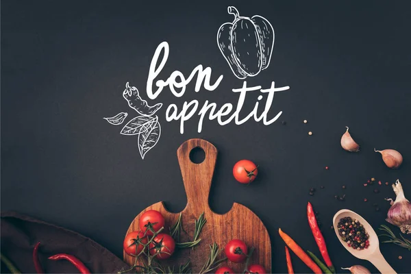 Top view of cherry tomatoes and fennel with garlic on gray table with bon appetit lettering — Stock Photo