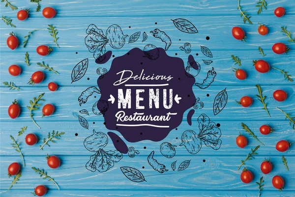 Vista superior de tomates cereja com arugula na mesa azul, delicioso menu restaurante lettering — Fotografia de Stock