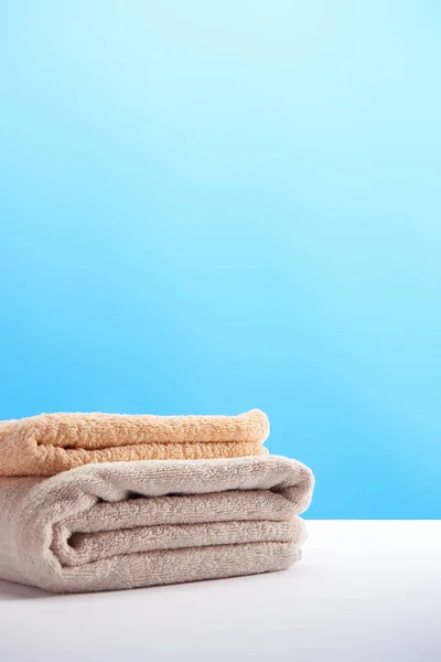 Stack of clean fresh soft towels on white table — Stock Photo