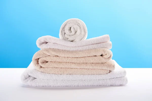 Close-up view of clean soft towels stacked on blue — Stock Photo