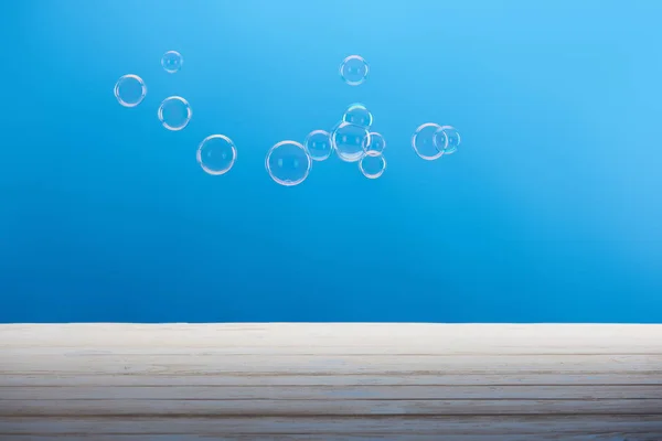 Saubere transparente Seifenblasen auf blauem Hintergrund — Stockfoto