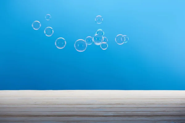 Clean transparent soap bubbles on blue background — Stock Photo