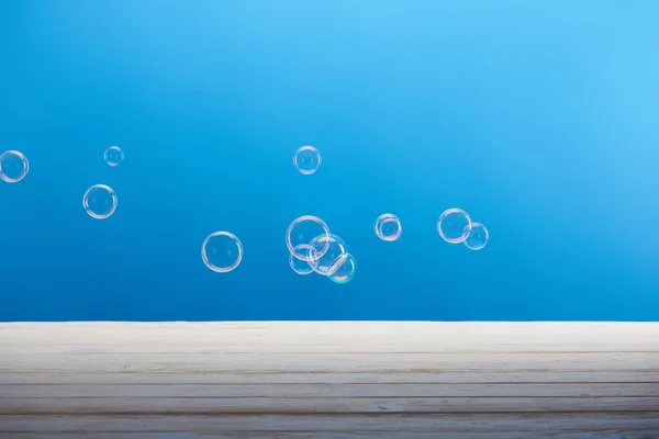 Limpar bolhas de sabão de lavanderia no fundo azul — Fotografia de Stock
