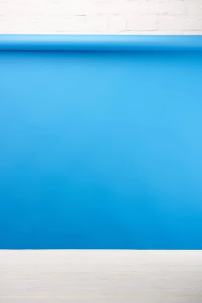 Голубой фон и светлая деревянная поверхность у стены из белого кирпича — стоковое фото