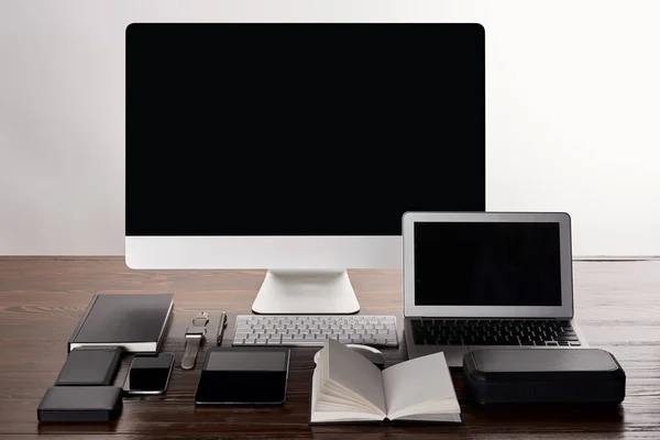 Monoblock computer with various gadgets on wooden table isolated on grey — Stock Photo